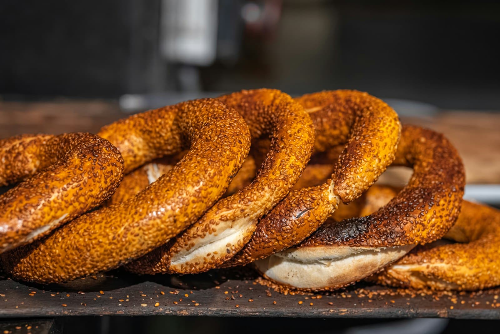 Frische Simit-Sesamringe auf einem dunklen Holzbrett